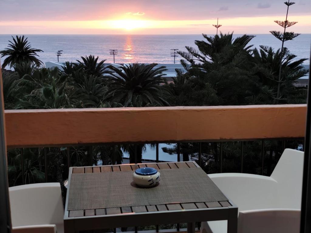 een vaas op een tafel op een balkon met uitzicht op de oceaan bij Valle Luz Apartment Ocean View in Puerto de la Cruz