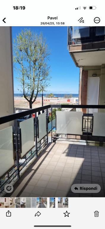 a balcony with benches and a tree on a building at Aria di mare in Rimini