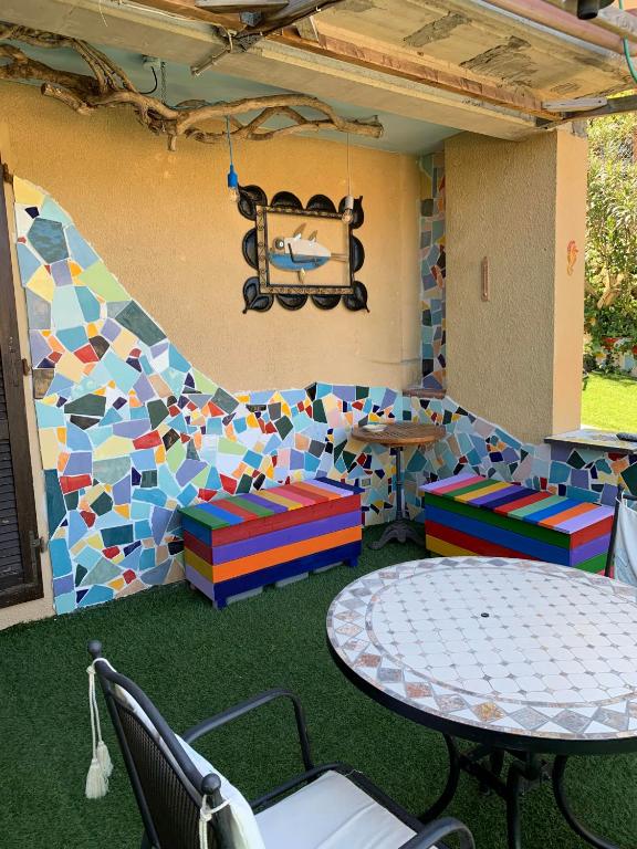 a play room with a table and chairs and a mosaic wall at Casa ARLECCHINA in Rio Marina