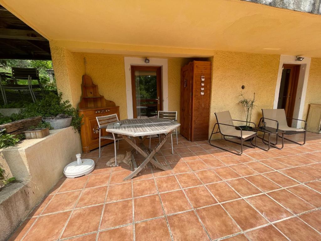 a patio with a table and chairs on it at la terrasse in Saint-Étienne-de-Tinée