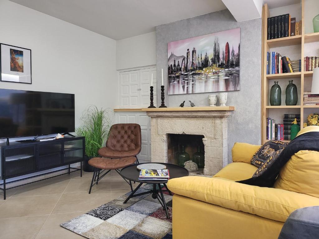 a living room with a yellow couch and a fireplace at Apartaments Font del Cirerer in Sant Hilari Sacalm