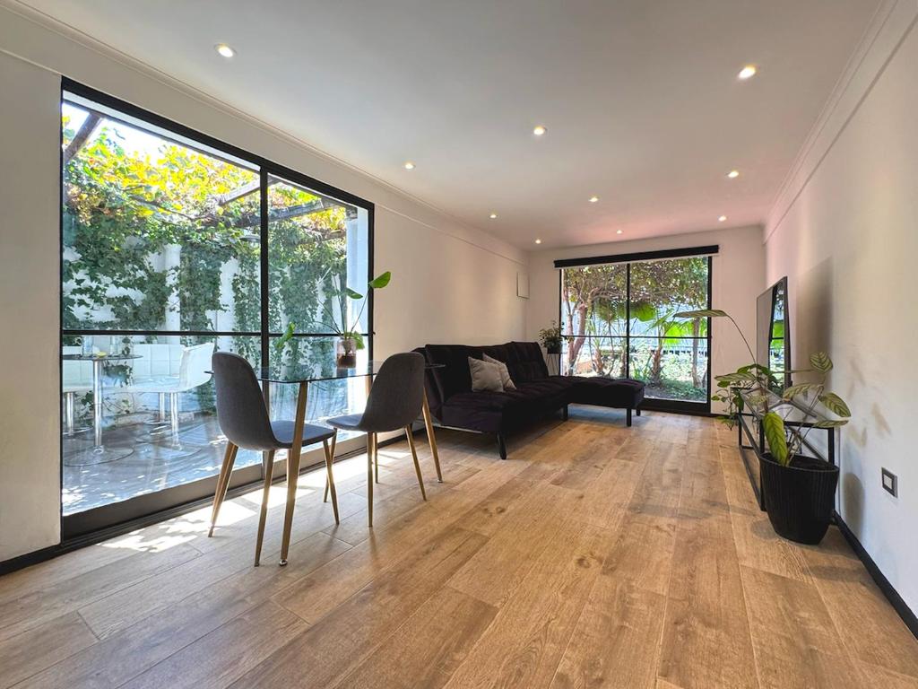 a living room with a couch and a table and chairs at Garden House Las Condes in Santiago