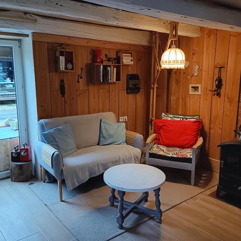 un salon avec un canapé et une table dans l'établissement Mon petit cocon jurassien, 