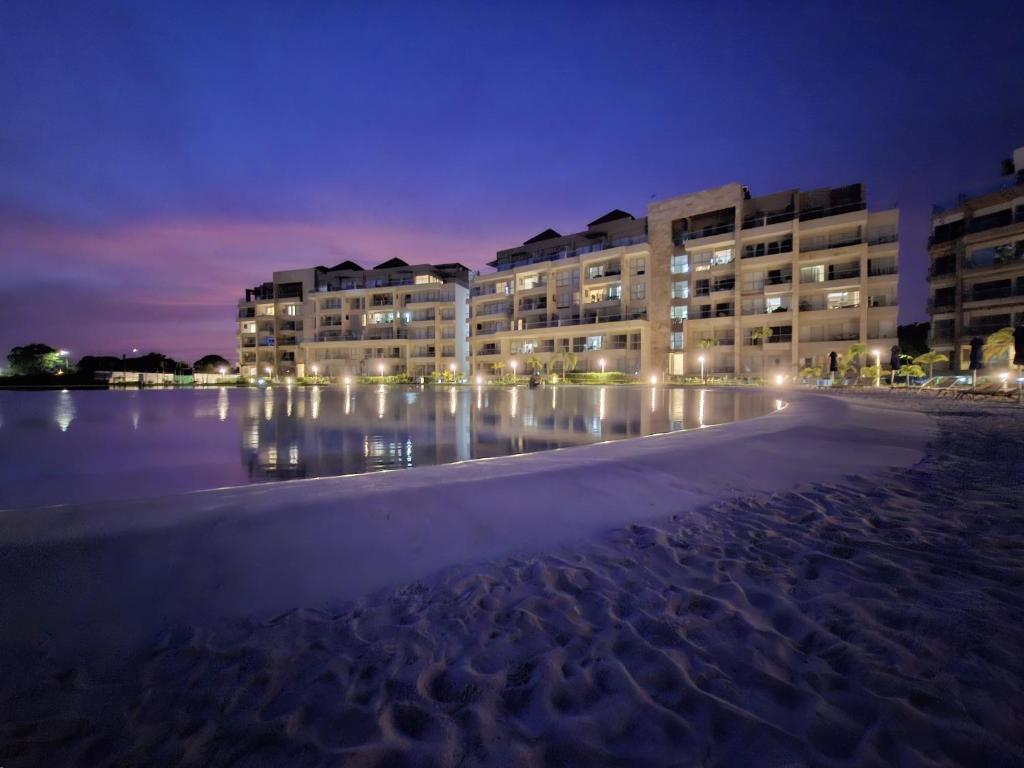 - un bâtiment sur la plage la nuit avec des lumières dans l'établissement Baia Kristal - Vacaciones Cartagena Colombia, à Carthagène des Indes