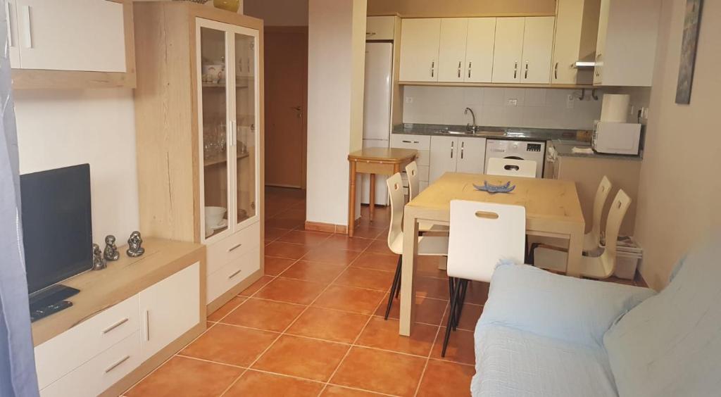a kitchen with a table and a small kitchen with a table and chairs at Apartamento Pescadores in Les Cases d'Alcanar