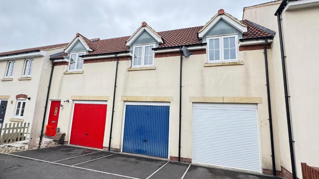 una hilera de garajes con puertas rojas y azules en Emerald dream house, en Swindon