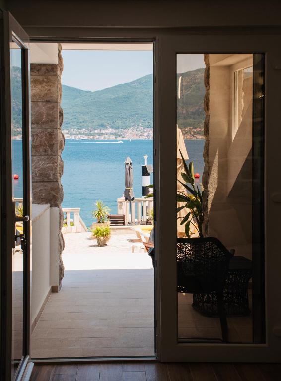 a door to a balcony with a view of the ocean at Apartments Kostic- Sea view in Tivat