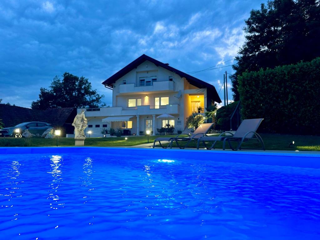 a house with a swimming pool at night at Apartman Perla in Gornji Kraj