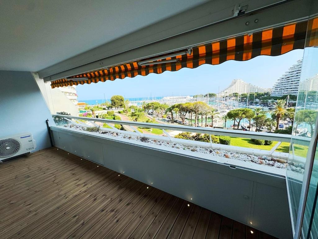 Elle comprend un balcon doté d'une grande fenêtre offrant une vue sur la ville. dans l'établissement #S21 Chic Escape - Sea & Port View - Marina, à Villeneuve-Loubet