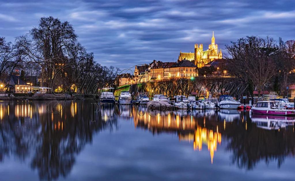 un groupe de bateaux amarrés dans une rivière la nuit dans l'établissement Le Cosy d'Asfeld, à Metz
