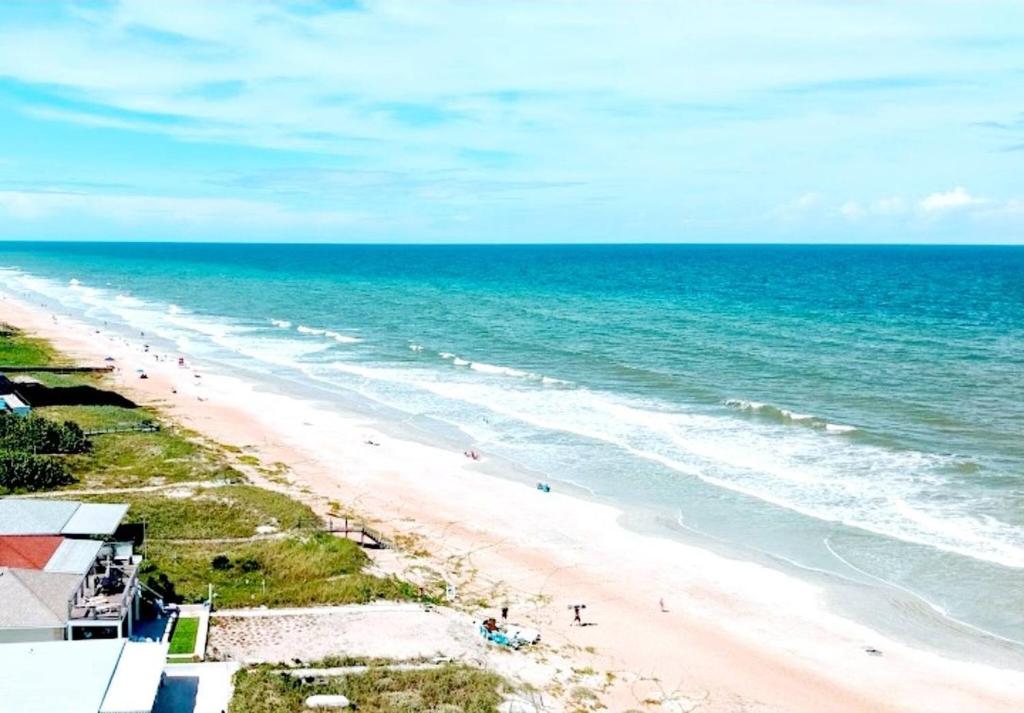 an overhead view of a beach with people on it at Quiet direct oceanfront 2 bed 2 bath condo w/pool in Ormond-by-the-Sea