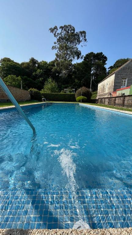 a large swimming pool with blue water at Pombal Bayona in Baiona