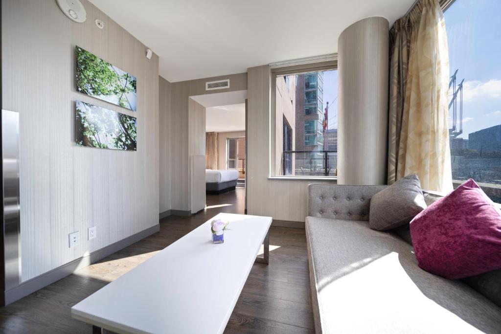 a living room with a couch and a large window at Hotel BLU in Vancouver