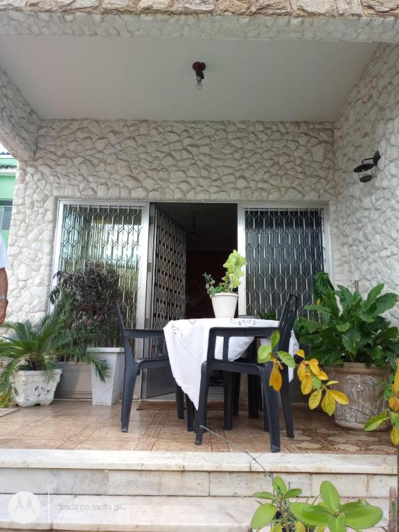 a table and chairs on a patio with plants at Casa Bromélia in Ricardo de Albuquerque