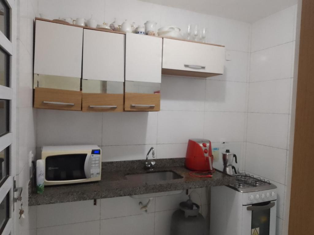 eine kleine Küche mit Spüle und Mikrowelle in der Unterkunft Casa para alugar São João de CG PB in Campina Grande