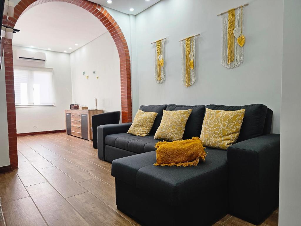 a living room with a blue couch with yellow pillows at O Refúgio in Reguengos de Monsaraz
