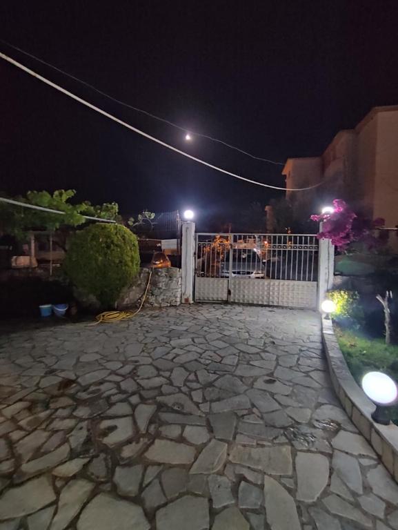 a fence with a stone patio at night at Villa Sidorela in Ksamil