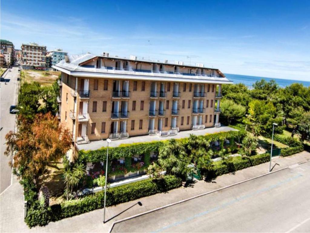 um edifício de apartamentos com um jardim em frente a uma rua em Hotel Parco em San Benedetto del Tronto