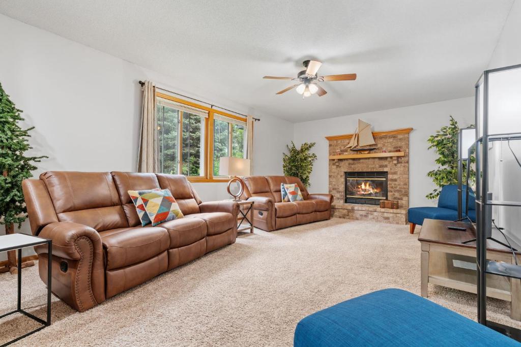 a living room with leather furniture and a fireplace at Ultimate Family Fun Escape in Champlin
