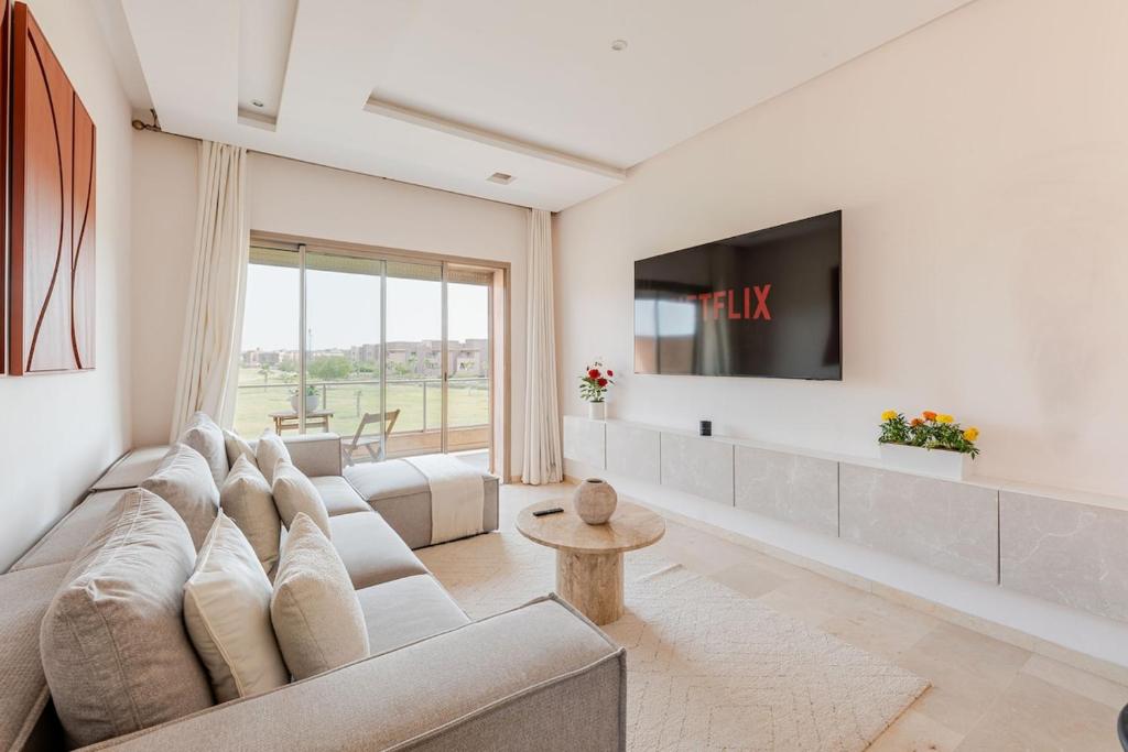 a living room with a couch and a tv at Luxury Appartement Golf and Pool in Marrakech