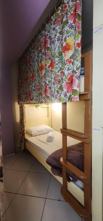 a bedroom with a bunk bed with a curtain at Hostel em Brusque - para quem busca economia - Ótima localização in Brusque