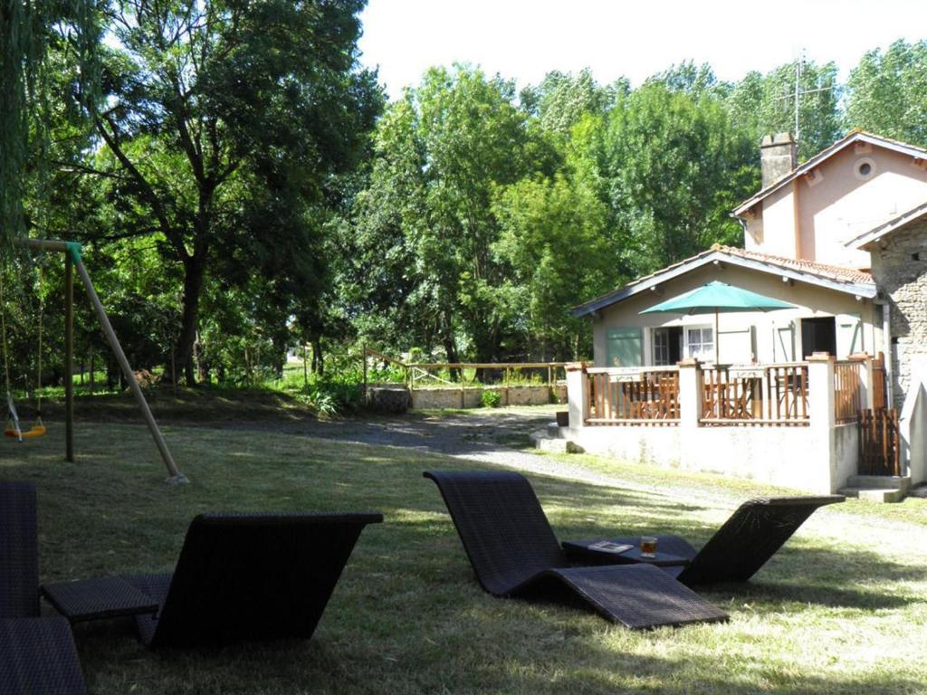 a group of chairs in a yard with a house at Gîte de caractère avec étang privé, jardin clos et cheminée, parfait pour les familles - FR-1-426-121 in Payré-sur-Vendée