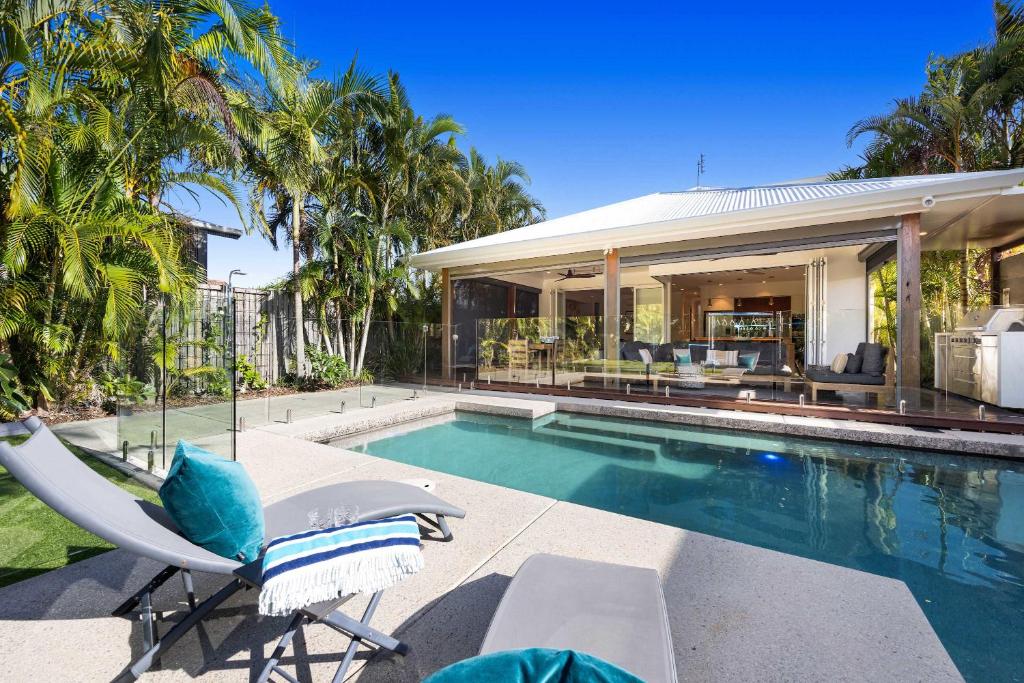 a villa with a swimming pool and a house at Golden Beach Luxury for Families in Golden Beach