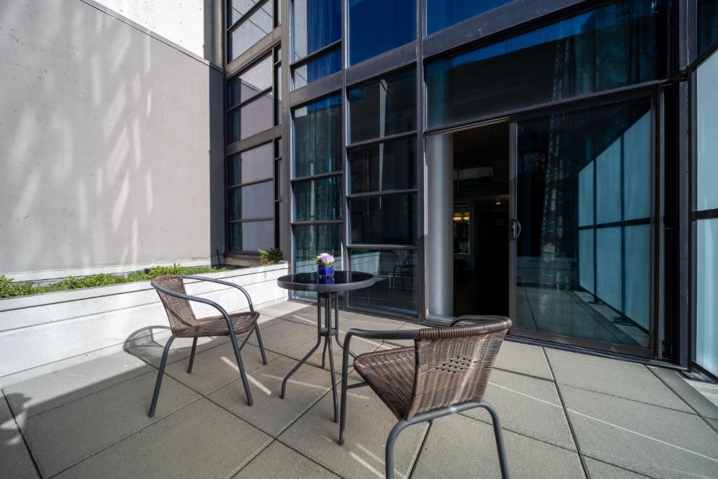 a patio with two chairs and a table on a building at Hotel BLU in Vancouver