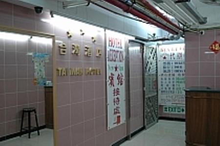 香港的住宿－1ST Homestay - HK Tai Wan Hostel，浴室设有粉红色的瓷砖墙壁和墙上的标志
