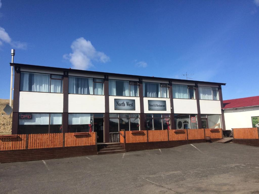 um edifício com muitas janelas num parque de estacionamento em North West Restaurant & Guesthouse em Víðigerði