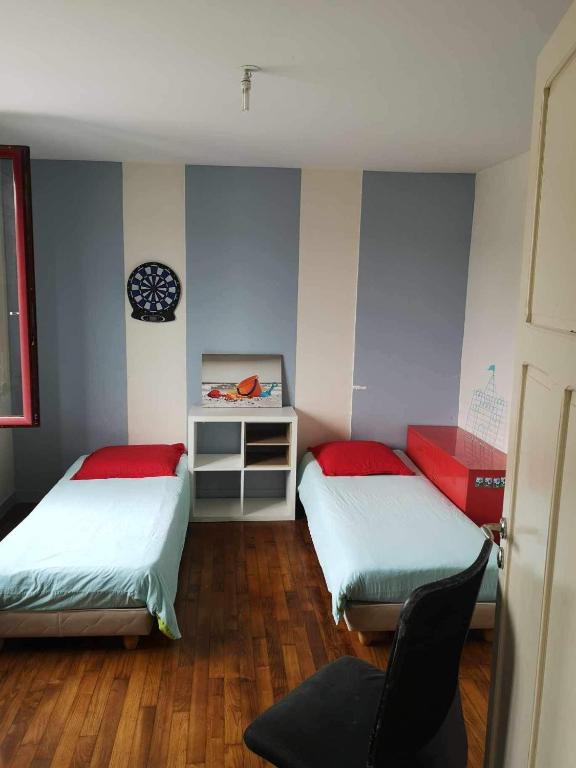 une chambre avec deux lits et une chaise dedans dans l'établissement Chez nous, à La Celle-sous-Gouzon