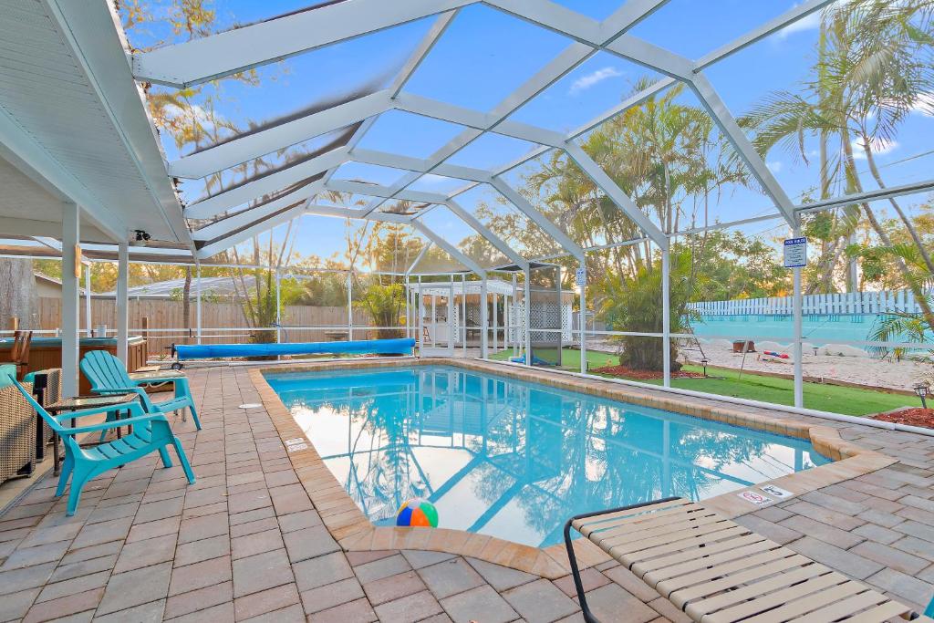 a swimming pool with a patio with a table and chairs at 5 Bed Heated Pool Largo, Seminole FL 2 mi Indian Rocks Beach , Pets, Game room in Seminole