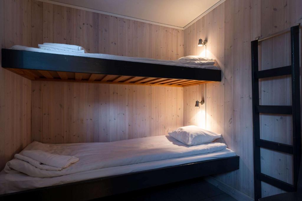 two bunk beds in a wooden walled room at Ice Hotel in Jukkasjärvi