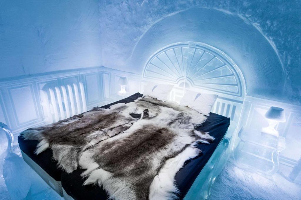 a blue room with a bed in an ice room at Ice Hotel in Jukkasjärvi