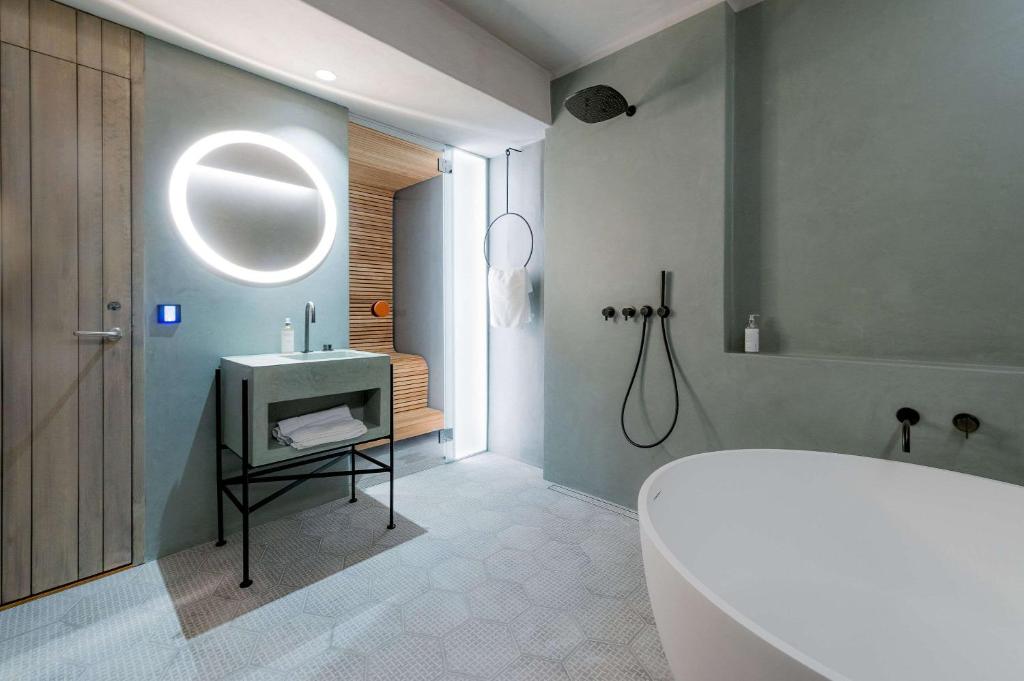 a bathroom with a tub and a sink and a mirror at Ice Hotel in Jukkasjärvi