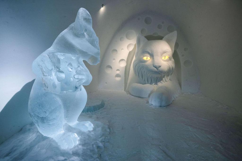 a cat sitting in a room with an ice sculpture at Ice Hotel in Jukkasjärvi
