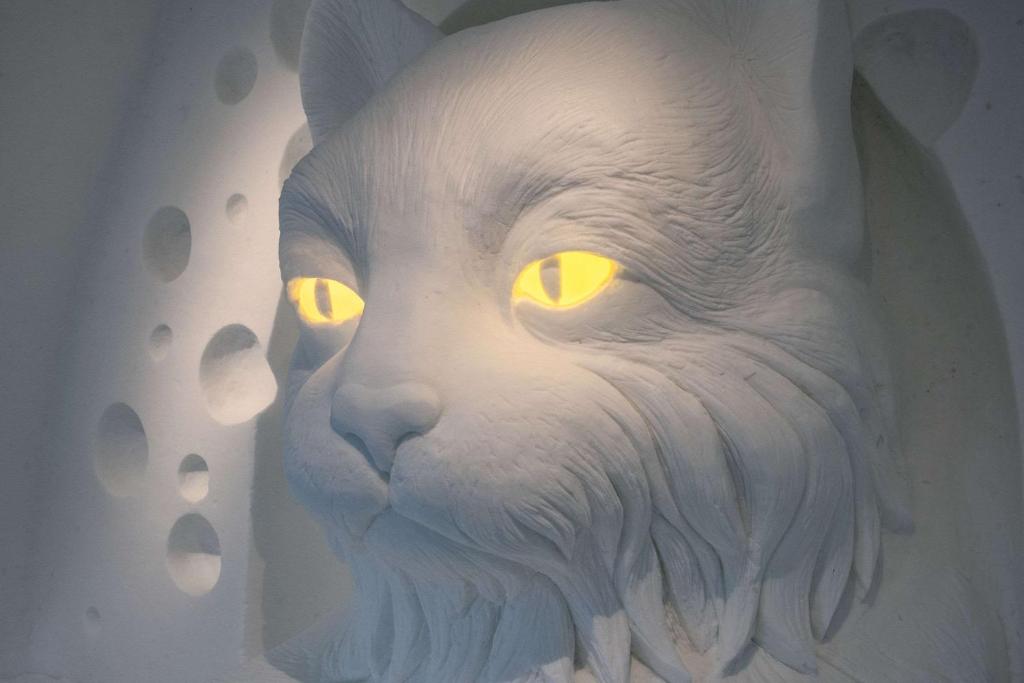 a statue of a white cat with yellow eyes at Ice Hotel in Jukkasjärvi