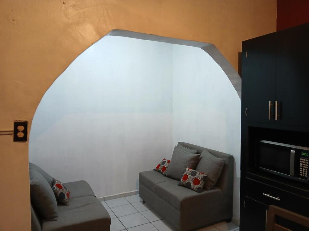 ein Wohnzimmer mit Sofa und Fernseher in der Unterkunft Departamento chico para tu estancia en ciudad juarez in Zaragoza
