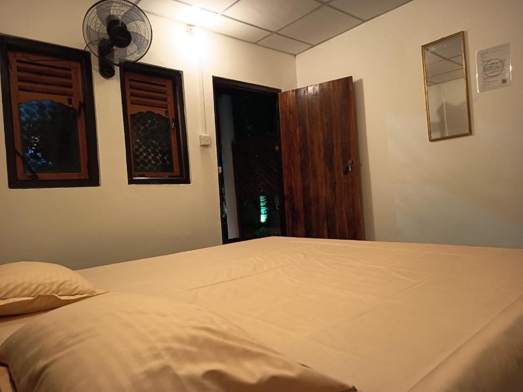 Postel nebo postele na pokoji v ubytování Seaside Inn Arugambay