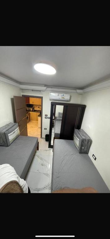 a room with two beds and a room with a kitchen at New golf bay in Banī Ghālib
