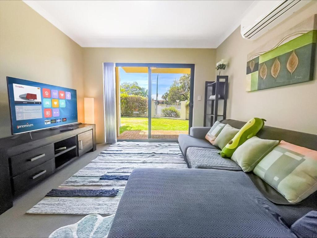 a living room with a couch and a flat screen tv at Ground Garden-Two King Beds&One Queen Bed in Perth
