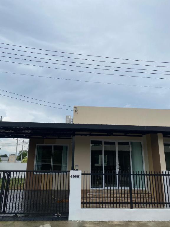 a house with a fence in front of it at FUJI Hotel in Nakhon Ratchasima