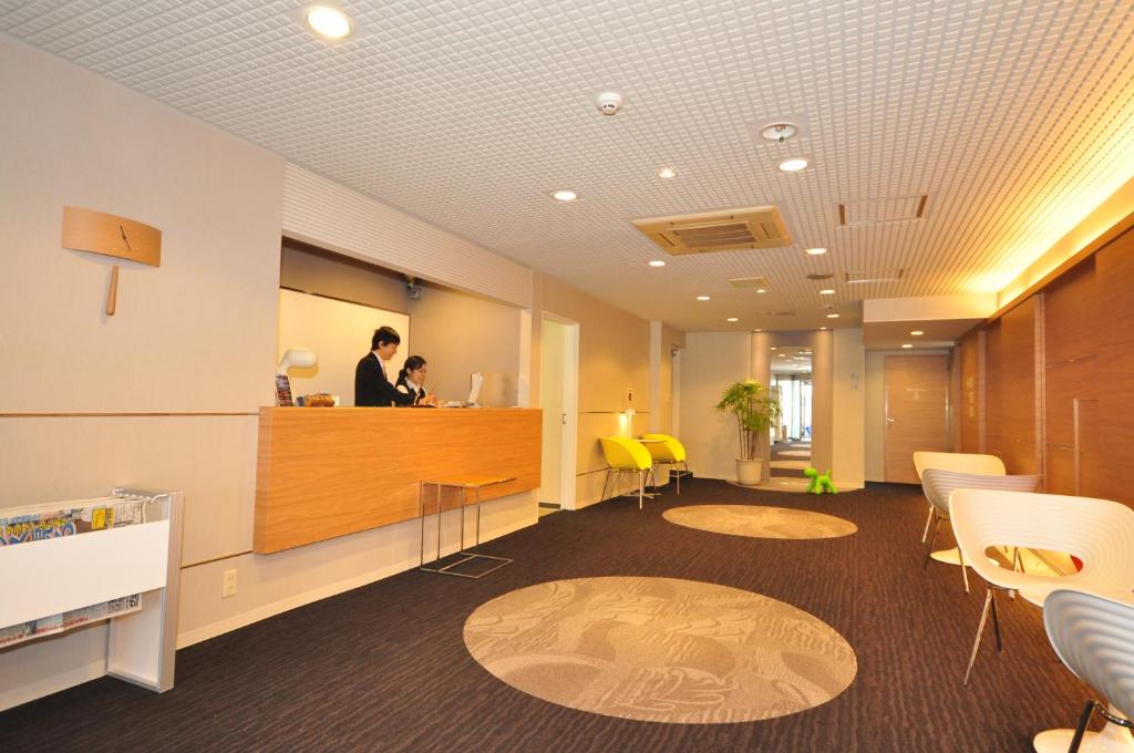 an office with a man standing at a counter at Hotel Green Well in Sendai