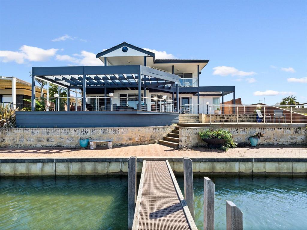 a house with a dock in front of a body of water at Private Jetty -Family & Pet Friendly in Mandurah