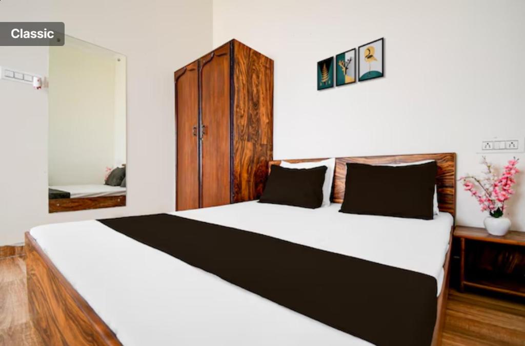 a bedroom with a large bed with a wooden cabinet at The Vasudha Estate in Lucknow