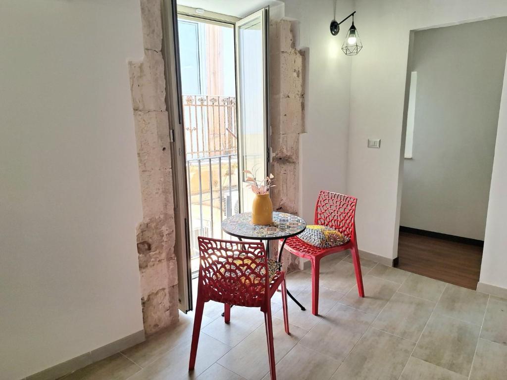 a table and chairs in a room with a window at Nata Sicula 3 in Siracusa