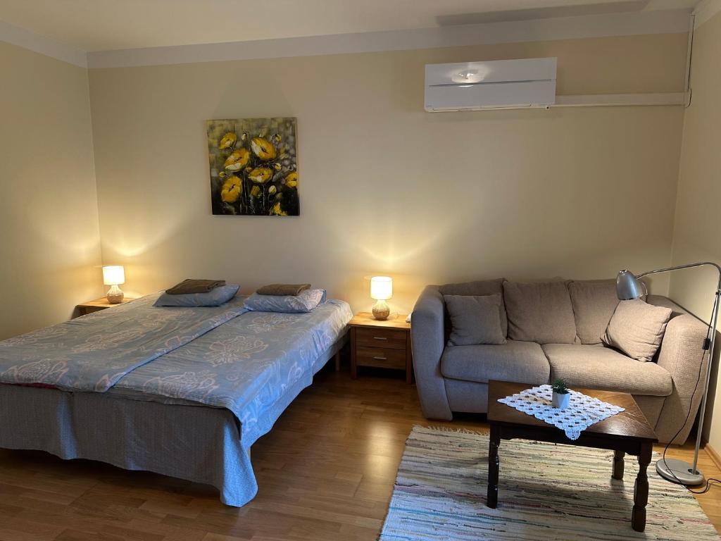 a living room with a bed and a couch at Haapsalu Old Town Apartment in Haapsalu