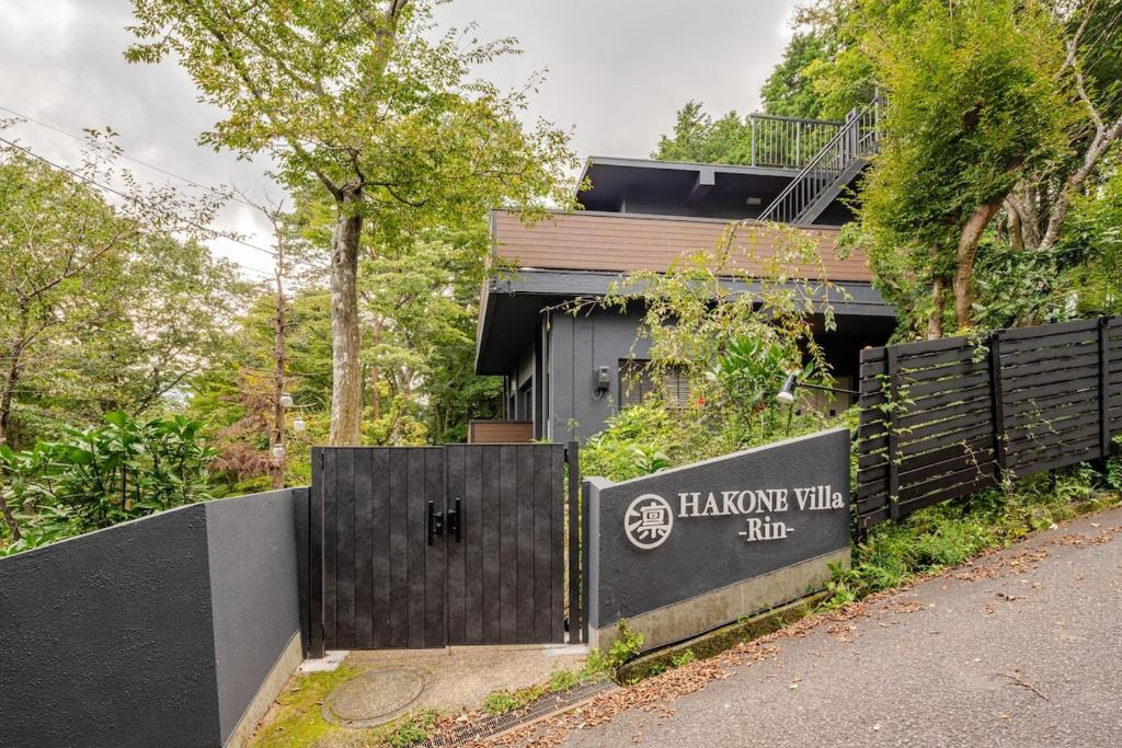 una casa con una recinzione nera e un cartello di HAKONE Villa-Rin- 052H a Hakone