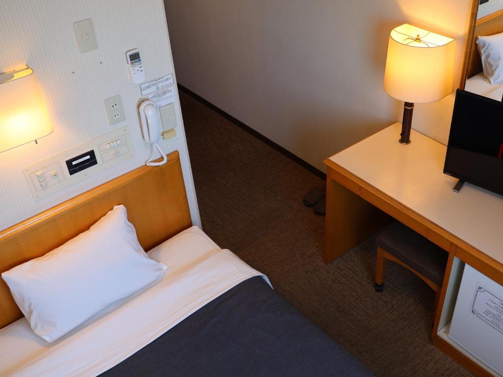 Postel nebo postele na pokoji v ubytování Sakaide Grand Hotel