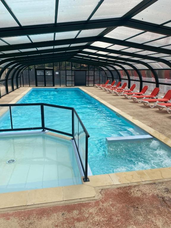 une grande piscine avec des chaises dans un bâtiment dans l'établissement Mobil home dans camping 4 étoiles au calme, à Saint-Hilaire-de-Riez